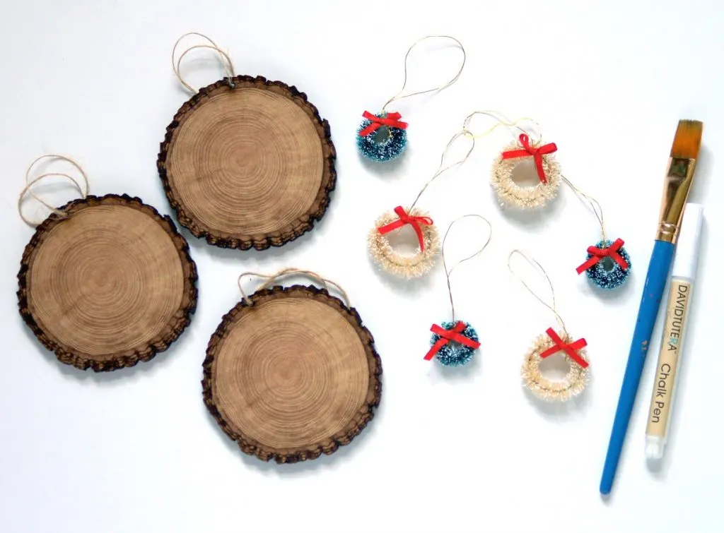 Cute little wood slice DIY holiday ornaments are a fun little gift idea and a great embellishment to add to gift wrap